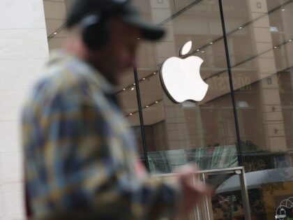 BERLIN, GERMANY - APRIL 23: A man with headphones and carrying a smartphone walks past an