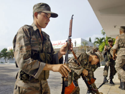 Cuban soldiers hold their weapons Tuesday, Sept. 10, 2002 at Cuban Base headquarters in Gu